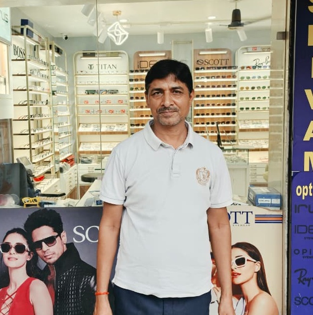 Arvind Dwivedi standing outside Shivam Opticals showroom